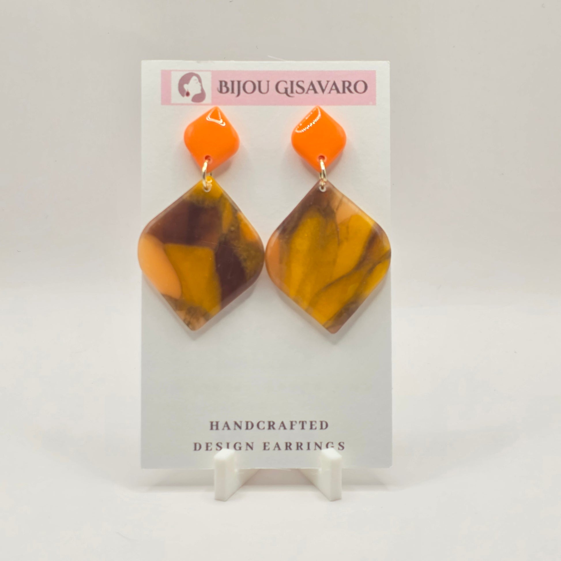 De Amber Orange Glow Statement Oorbellen zijn handgemaakte oorbellen met een warme en opvallende kleurencombinatie van fel oranje, amber, okergeel en diepbruin. De gemarmerde hanger heeft een organisch patroon, waardoor iedere oorbel een unieke uitstraling heeft.

De feloranje bovenkant geeft het ontwerp een frisse kleurboost, terwijl de warme amber- en bruintinten voor een stijlvolle balans zorgen. Een echte statement oorbel die zowel bij neutrale als kleurrijke outfits prachtig tot zijn recht komt.

Detai