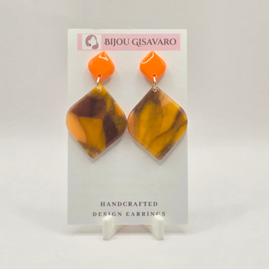 De Amber Orange Glow Statement Oorbellen zijn handgemaakte oorbellen met een warme en opvallende kleurencombinatie van fel oranje, amber, okergeel en diepbruin. De gemarmerde hanger heeft een organisch patroon, waardoor iedere oorbel een unieke uitstraling heeft.

De feloranje bovenkant geeft het ontwerp een frisse kleurboost, terwijl de warme amber- en bruintinten voor een stijlvolle balans zorgen. Een echte statement oorbel die zowel bij neutrale als kleurrijke outfits prachtig tot zijn recht komt.

Detai