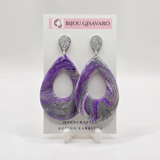 De Amethyst Silver Statement Oorbellen zijn handgemaakte blikvangers met een prachtige combinatie van paars, zilver en grijstinten. Het gemarmerde patroon en de subtiele glinstering geven iedere oorbel een uniek karakter.

De grote open druppelvorm zorgt voor een elegante statement look, terwijl de zilverkleurige steker het ontwerp een moderne en stijlvolle afwerking geeft. Perfect om een eenvoudige outfit nét dat beetje extra te geven.

Details

Handgemaakt
Kleur: paars, zilver & grijs
Gemarmerd design met
