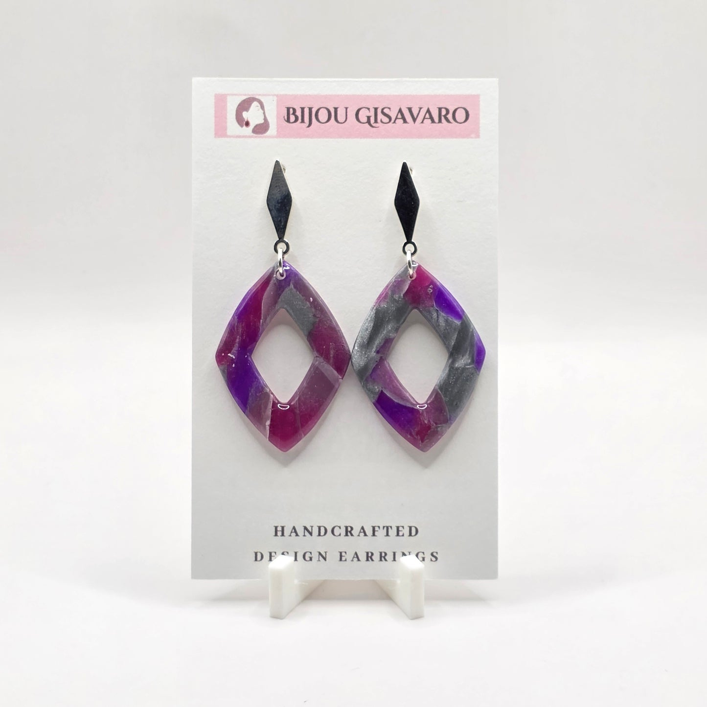 De Amethyst Statement Oorbellen zijn handgemaakte oorbellen met een stijlvolle combinatie van paars, fuchsia, en zilvergrijs. Het gemarmerde patroon zorgt voor een speels kleurverloop en maakt ieder paar uniek.

De open geometrische ruitvorm wordt gecombineerd met een elegante zwarte steker, waardoor deze oorbellen een moderne en krachtige uitstraling krijgen. Met slechts 2,2 gram per oorbel zijn ze opvallend én licht om te dragen.

Details

Handgemaakt
Kleur: paars, fuchsia,&nbsp; &amp; zilvergrijs
Op