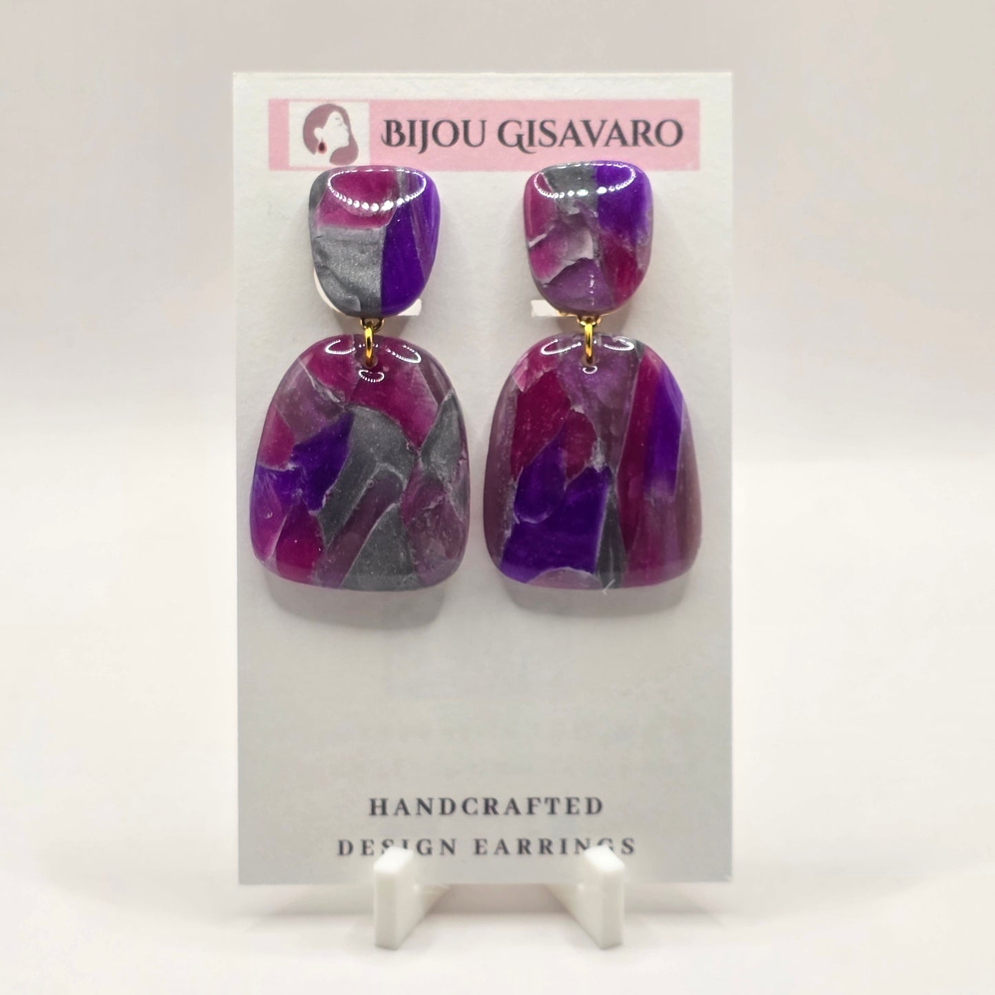 De Berry Amethyst Statement Clips Oorbellen zijn handgemaakte oorclips met een krachtige mix van paars, fuchsia, roze en zilvergrijze tinten. Het gemarmerde patroon geeft iedere oorbel een eigen uitstraling, waardoor elk paar uniek is.

Het moderne geometrische ontwerp bestaat uit twee afgeronde vormen met een subtiel goudkleurig verbindingsringetje. Dankzij de clipsluiting zijn deze statement oorbellen ideaal voor wie geen gaatjes heeft en toch opvallende oorbellen wil dragen.

Details

Handgemaakt
Oorclip