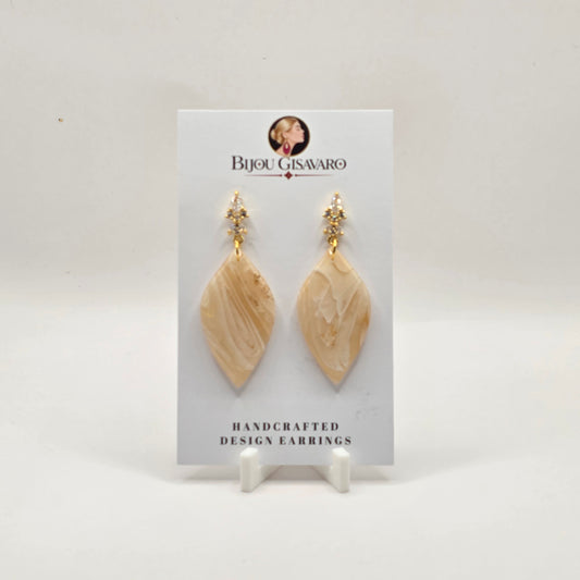 De statement oorbellen Champagne Elegance zijn handgemaakte oorbellen met een elegante en luxueuze uitstraling. De hanger heeft een verfijnde combinatie van champagne, ivoor en crème, afgewerkt met een subtiele glans en een uniek gemarmerd patroon.

De sierlijke goudkleurige steker met fonkelende steentjes geeft deze oorbellen een chique uitstraling. Perfect voor een feestelijke gelegenheid, maar ook stijlvol bij een elegante dagelijkse outfit. Door het handgemaakte karakter is ieder paar uniek.

Detai
