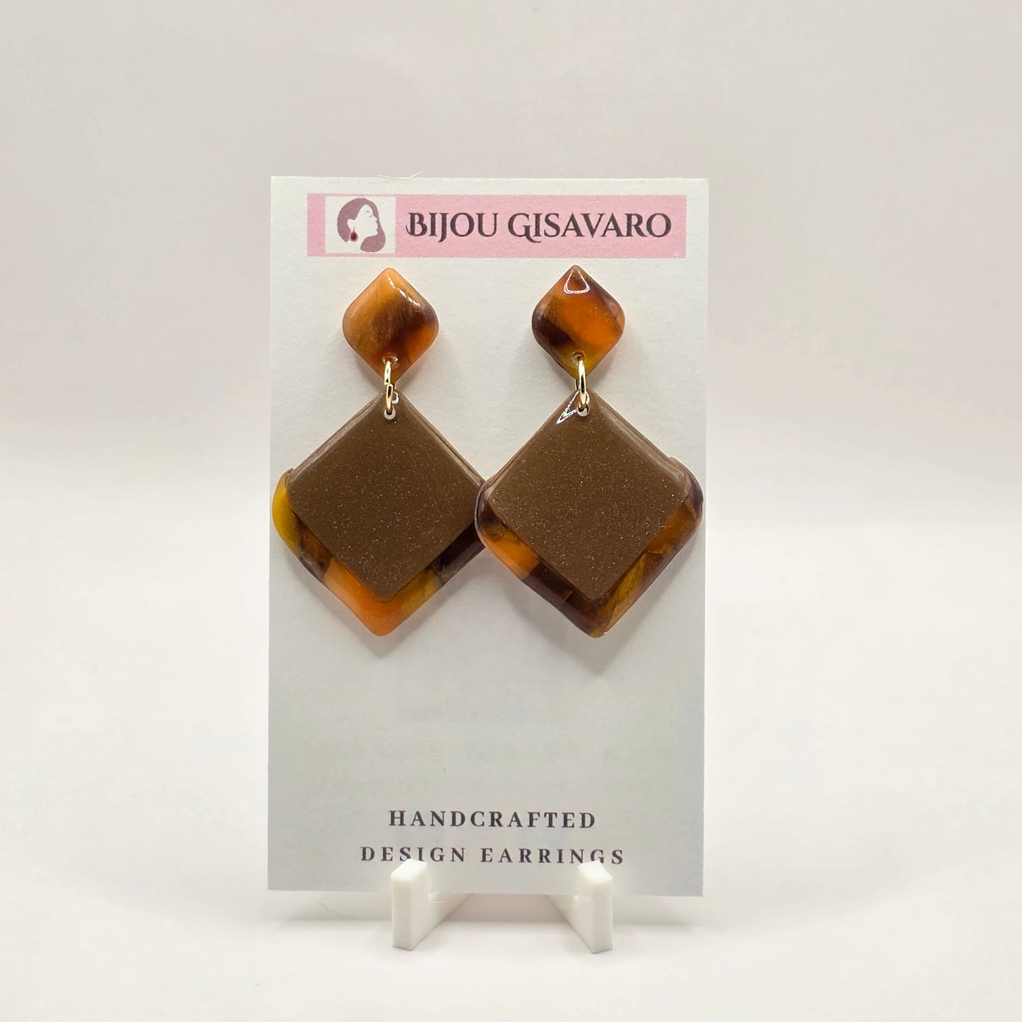 De Golden Mocha Statement Oorbellen zijn handgemaakte statement oorbellen met een warme en elegante uitstraling. De combinatie van taupe, goudbruin, amber en subtiele glinstering zorgt voor een luxueus en bijzonder effect.

Het geometrische ontwerp met de grote ruitvorm maakt deze oorbellen opvallend, zonder zwaar aan te voelen. Met slechts 3,2 gram per oorbel zijn ze comfortabel om te dragen. Door het handgemaakte kleurpatroon is ieder paar uniek.

Details

Handgemaakt
Kleur: taupe, goudbruin & amber
Subti