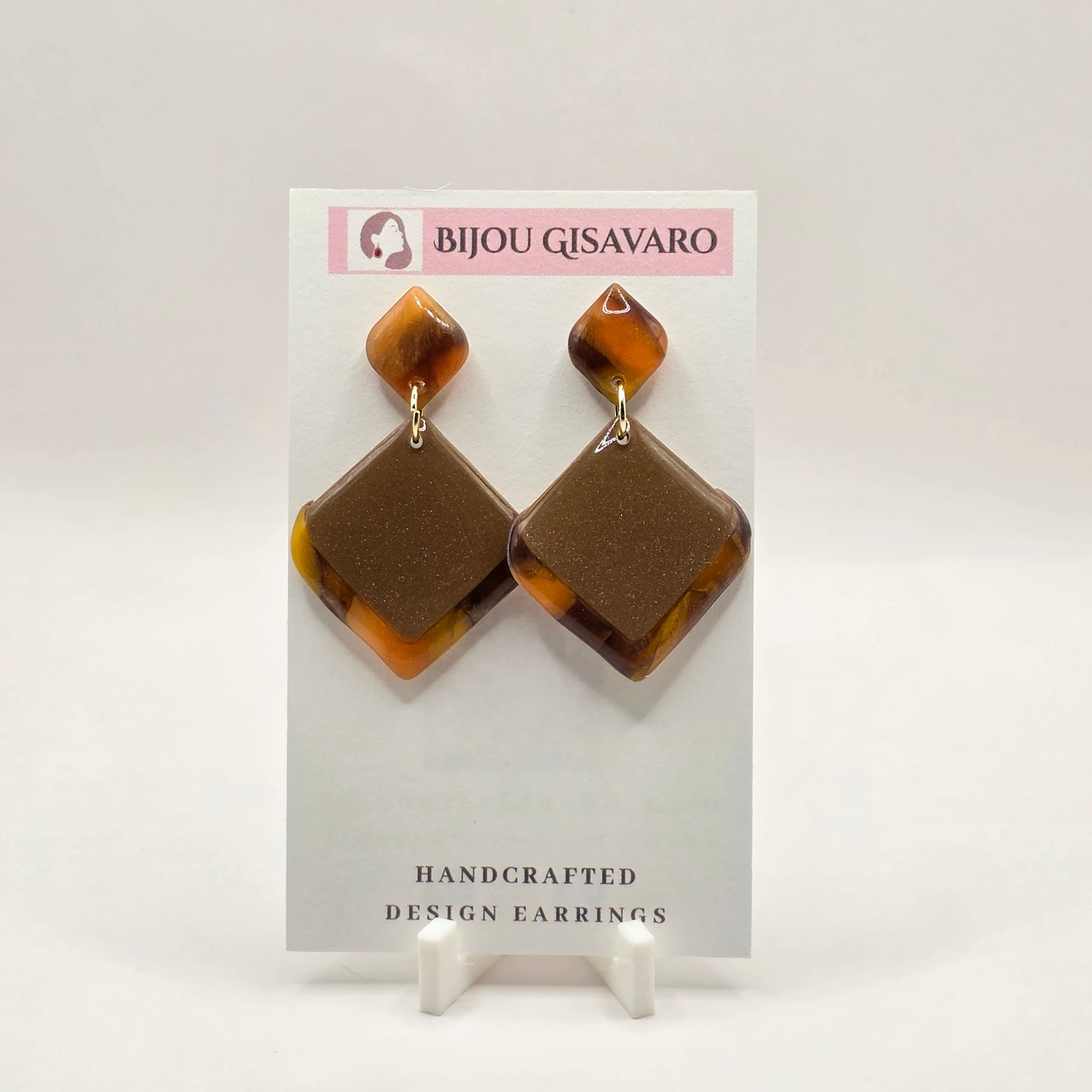De Golden Mocha Statement Oorbellen zijn handgemaakte statement oorbellen met een warme en elegante uitstraling. De combinatie van taupe, goudbruin, amber en subtiele glinstering zorgt voor een luxueus en bijzonder effect.

Het geometrische ontwerp met de grote ruitvorm maakt deze oorbellen opvallend, zonder zwaar aan te voelen. Met slechts 3,2 gram per oorbel zijn ze comfortabel om te dragen. Door het handgemaakte kleurpatroon is ieder paar uniek.

Details

Handgemaakt
Kleur: taupe, goudbruin & amber
Subti
