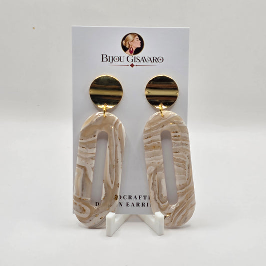 De statement oorbellen Ivory Golden Line zijn handgemaakte oorbellen met een moderne en elegante uitstraling. De langwerpige hanger combineert ivoorwit, crème en zachte champagnekleurige tinten in een uniek gemarmerd lijnpatroon.

De grote open vorm geeft het ontwerp een luchtige uitstraling, terwijl de glanzende goudkleurige ronde steker voor een luxueuze afwerking zorgt. Met hun lengte van 7 cm zijn het echte statement oorbellen die een outfit onmiddellijk extra uitstraling geven.

Details

Handgema