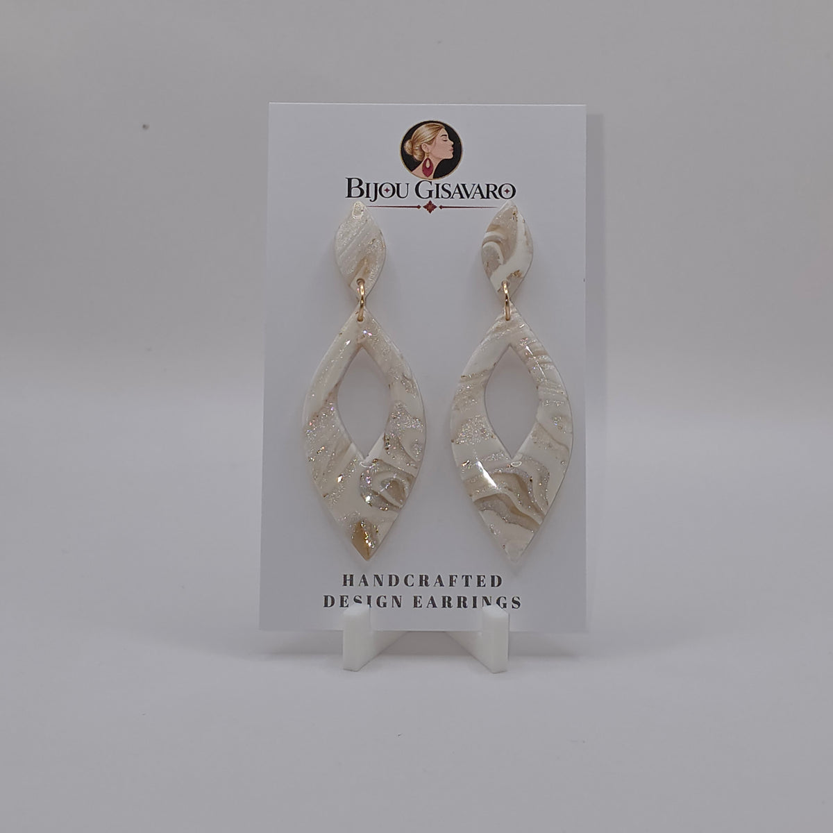 De statement oorbellen Ivory Golden Sparkle zijn handgemaakte oorbellen met een elegante en feestelijke uitstraling. De combinatie van ivoorwit, crème, champagne en subtiele goudaccenten wordt versterkt door een fijne glinstering in het gemarmerde patroon.

De langwerpige open vorm zorgt voor een verfijnde statement look, terwijl de goudkleurige verbindingsring het ontwerp stijlvol afwerkt. Met slechts 2,6 gram per oorbel zijn deze grote oorbellen bovendien verrassend licht om te dragen.

Details

Hand